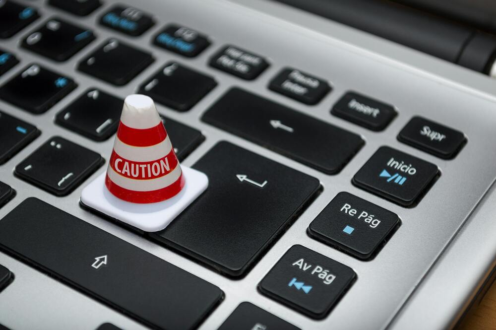 clavier d'ordinateur avec un poteau où il y a écrit caution
