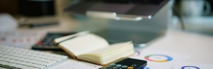 espace de travail avec un ordinateur, des papiers et une calculatrice